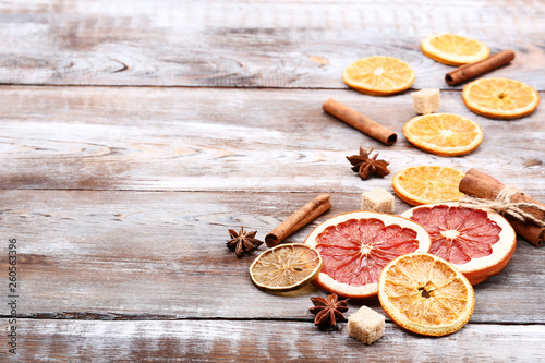 Dried citrus fruits with cinnamon, star anise and sugar cubes on brown wooden table