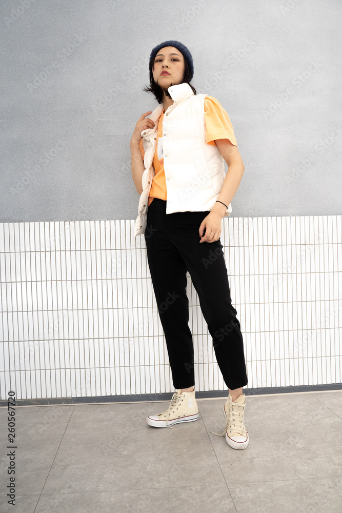 Asian chinese girl modeling with orange tshirt and black pants in sneaker Asian chinese girl modeling with orange tshirt and black pants in sneaker