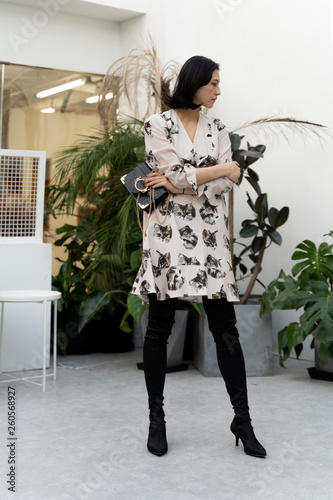 Asian chinese model  girl wearing a dress with black boots and handbag