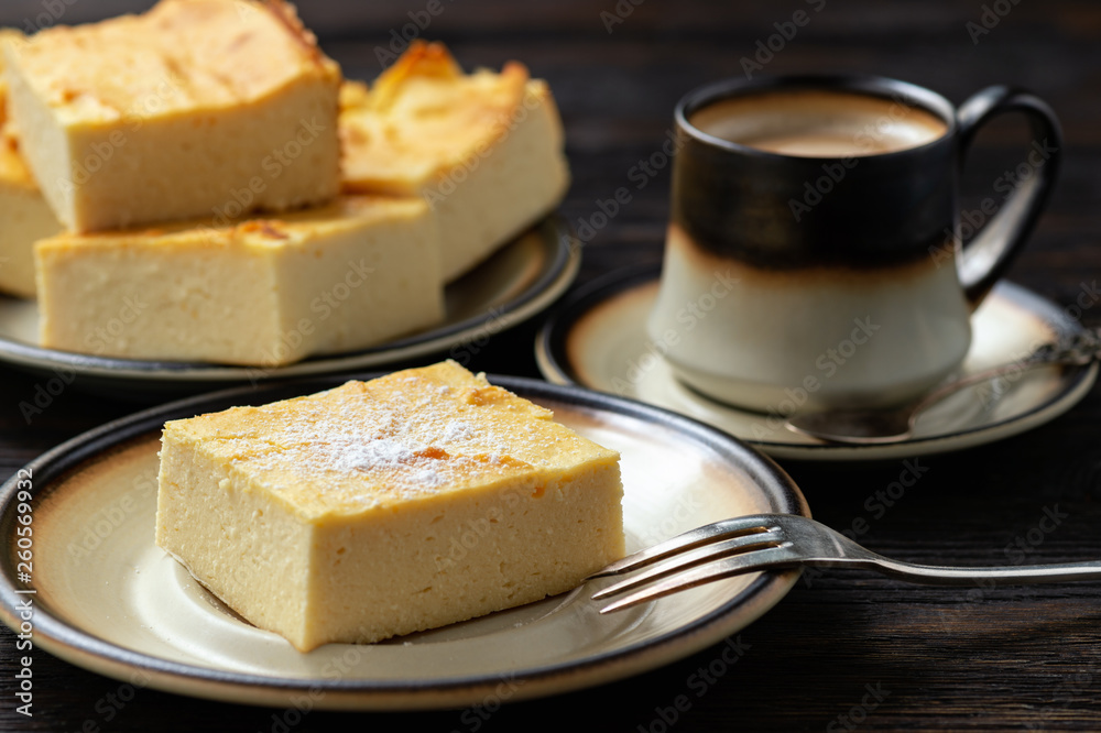 Homemade sliced cheesecake and the cup of coffee. 