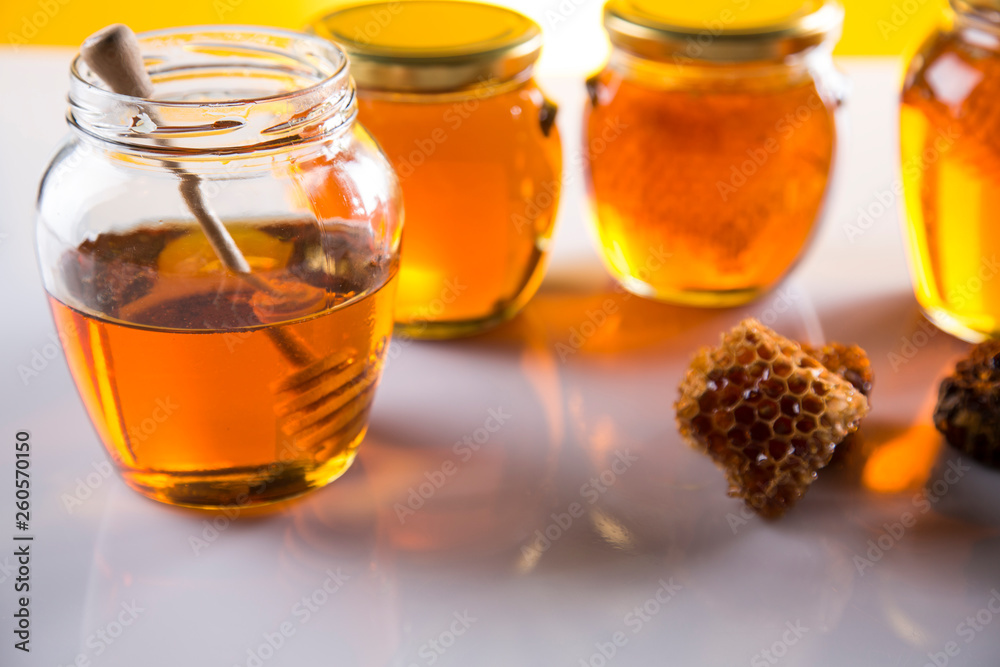 Honey in jar with honey dipper on wooden background Honey in jar with honey dipper on wooden background