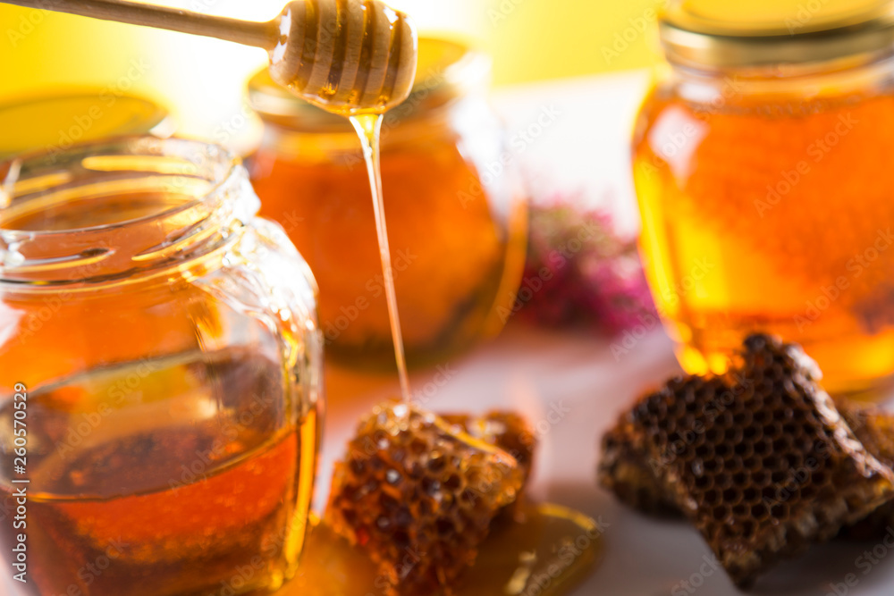 Honey in jar with honey dipper on wooden background Honey in jar with honey dipper on wooden background