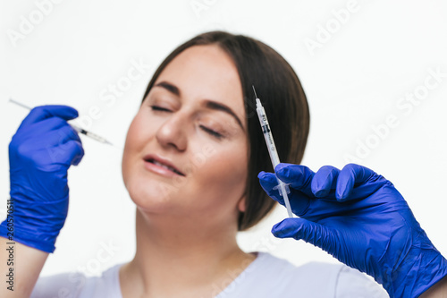 Young woman making anti-aging injections to increase the lips isolated on white background