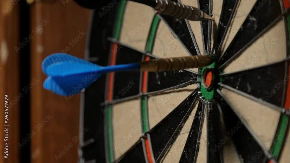 close up angle darts sticking into dart board