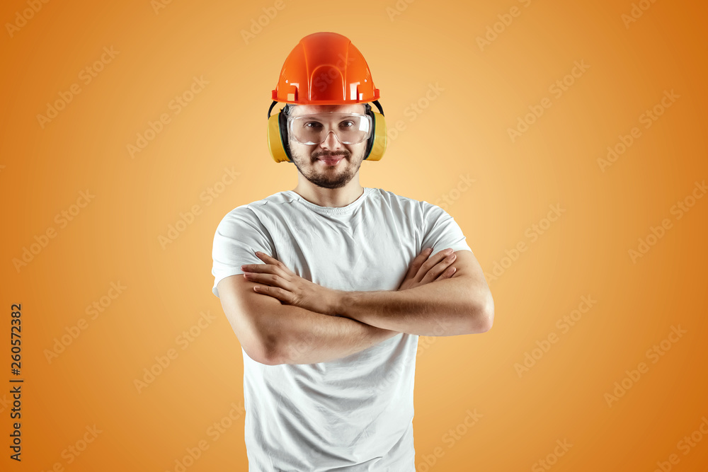 Male builder in orange helmet on an orange background. Concept of construction, contractor, repair.