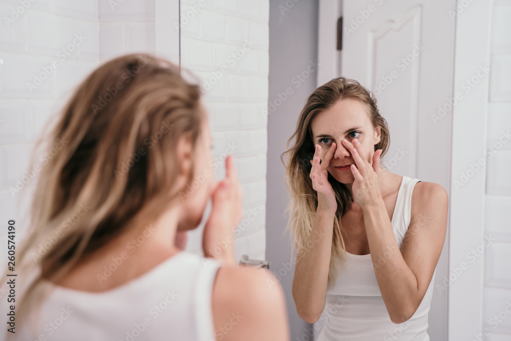 young woman mirrored in the bathroom to see her face begin to age young woman mirrored in the bathroom to see her face begin to age
