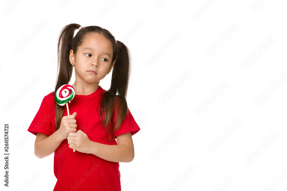 Beautiful upset little child girl with sweet candy lollipop isolated on white background Beautiful upset little child girl with sweet candy lollipop isolated on white background