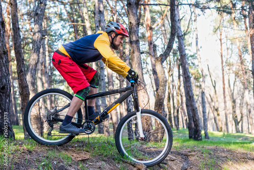 Cycling, a cyclist in bright clothes riding a mountain bike through the woods. Active lifestyle.