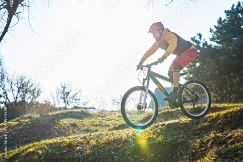 Fototapeta Naklejka Na Ścianę i Meble -  Professional cyclist driving down the hill, free space. Active lifestyle.