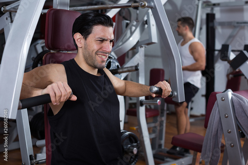 Man training on fitness machine in gym