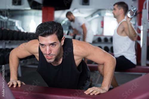 Man doing push-ups on bench in gym