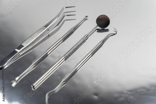 Set of professional dentist tools on gray metal background. Dental hygiene and health concept