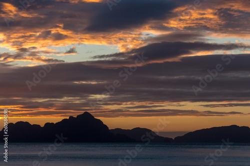 Philippines isles at sunset. Scenic sunset above sea. Travel and summer vacation concept. Island silhouette in evening dusk. Calm evening on tropical coast. Twilight at sea. 