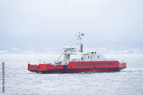 Red ship ferry transport over sea with vehicles onboard