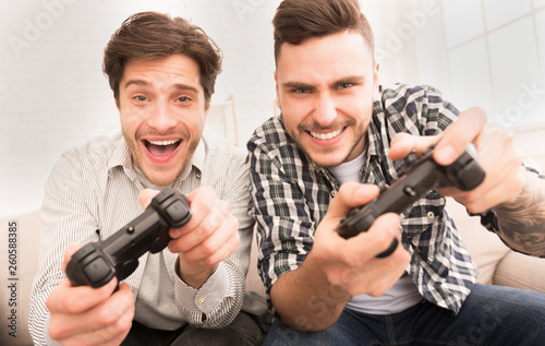 Gamers. Happy guys playing video games at home