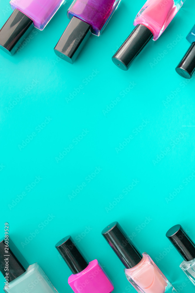 Bottles of nail polish. A group of bright nail polishes on a green background. With empty space in the middle. Bottles of nail polish. A group of bright nail polishes on a green background. With empty space in the middle.