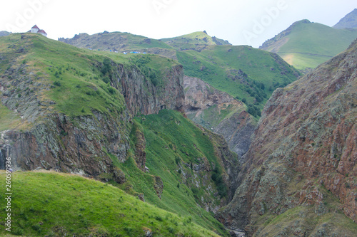 The Caucasus Mountains, high mountains, green meadows and snow-capped mountains.