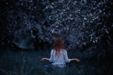 adult girl meditating in the lush apple orchard Spring
