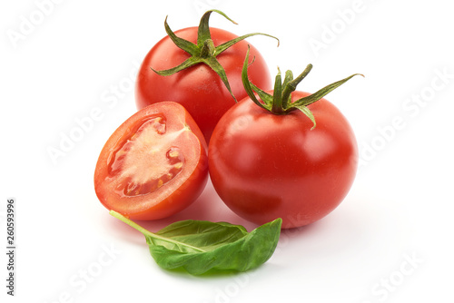 Fresh juicy tomatoes with green basil leaves, close-up, isolated on white background