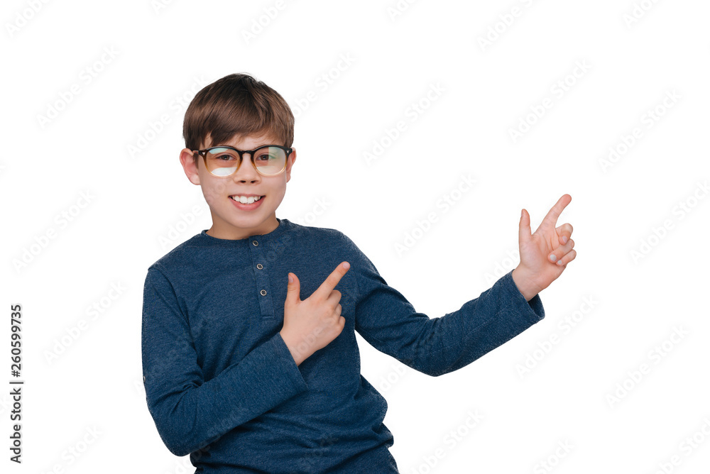 Cool little boy is pointing away while looking at camera over white wall Cool little boy is pointing away while looking at camera over white wall