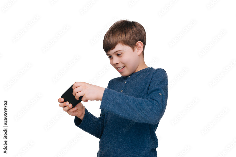 Handsome little boy playing in smartphone over white background Handsome little boy playing in smartphone over white background