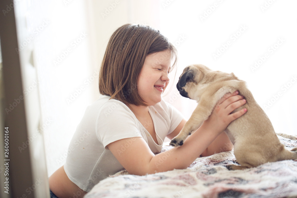 blonde girl with kisses and holds pug puppy blonde girl with kisses and holds pug puppy