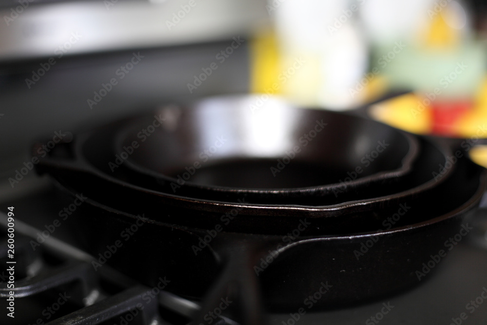 Cast iron skillets on a modern gas stove oven in a home. Cast iron skillets on a modern gas stove oven in a home.