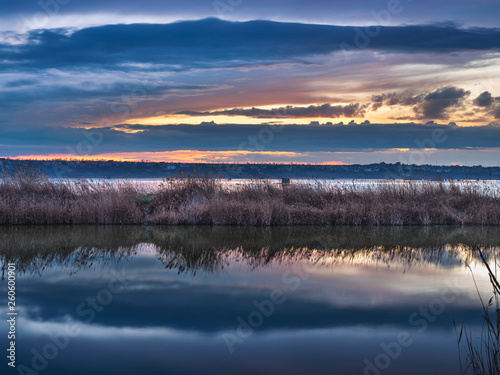 sunset with clouds and water reflections in lake