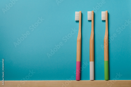 full colours bamboo toothbrushes on blue background. Place for text. Ecoproduct. 