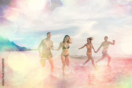 four friends are running on beach / summer vacation fun happiness, young men and women are running in the splashes of the sea along beach