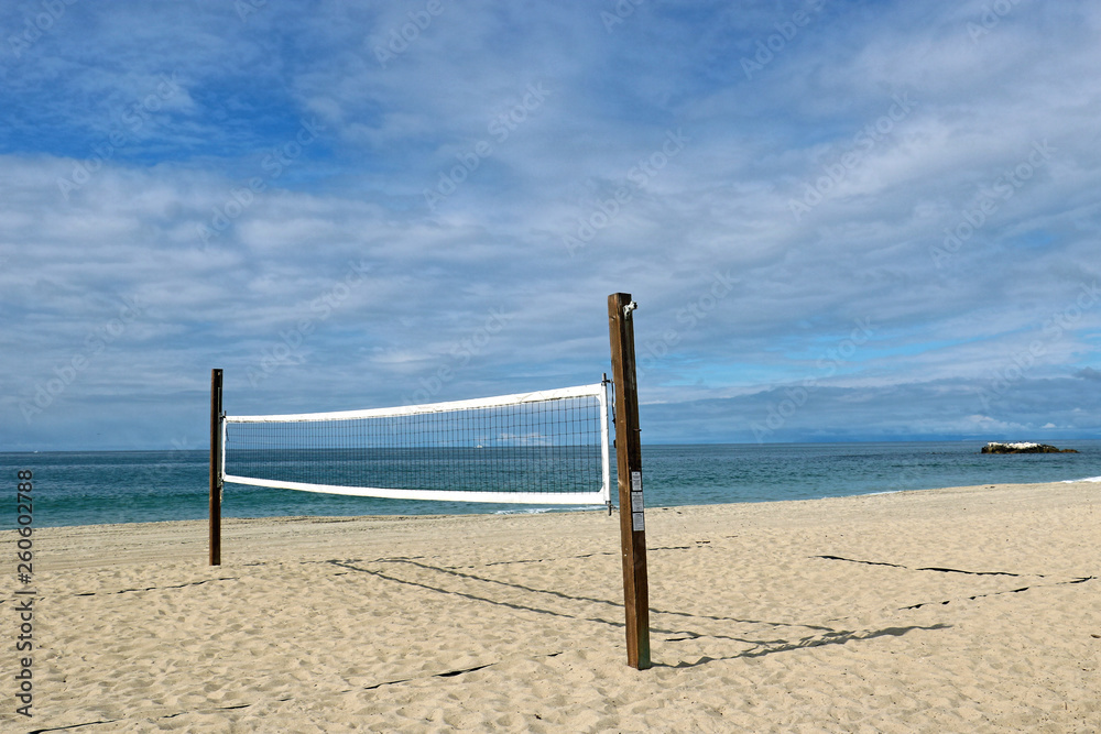 volleyball on the beach under a bluesky with clouds
