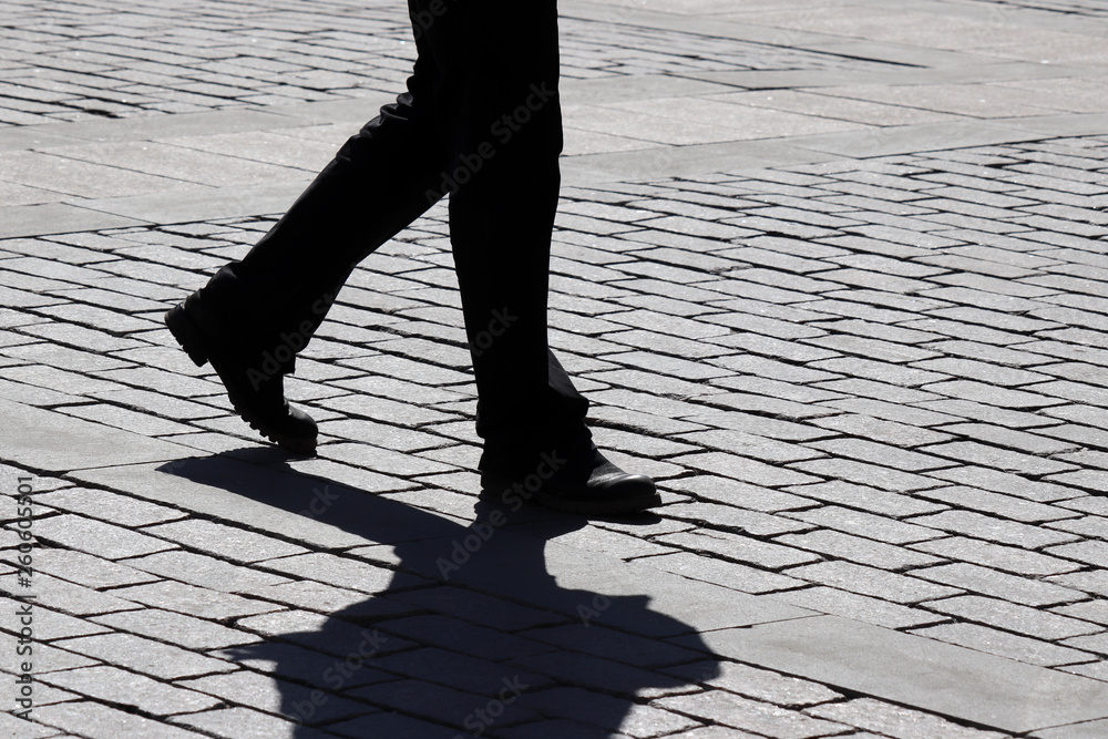 Black silhouette and shadow of man walking down the street. Hurrying man  outdoors, pedestrian, concept for dramatic life stories Stock Photo | Adobe  Stock
