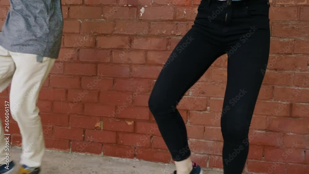 Street dance. Young couple of professional dancers dancing, breakdancing and performing freestyle dance in front of a red brick wall. 4K Street dance. Young couple of professional dancers dancing, breakdancing and performing freestyle dance in front of a red brick wall. 4K