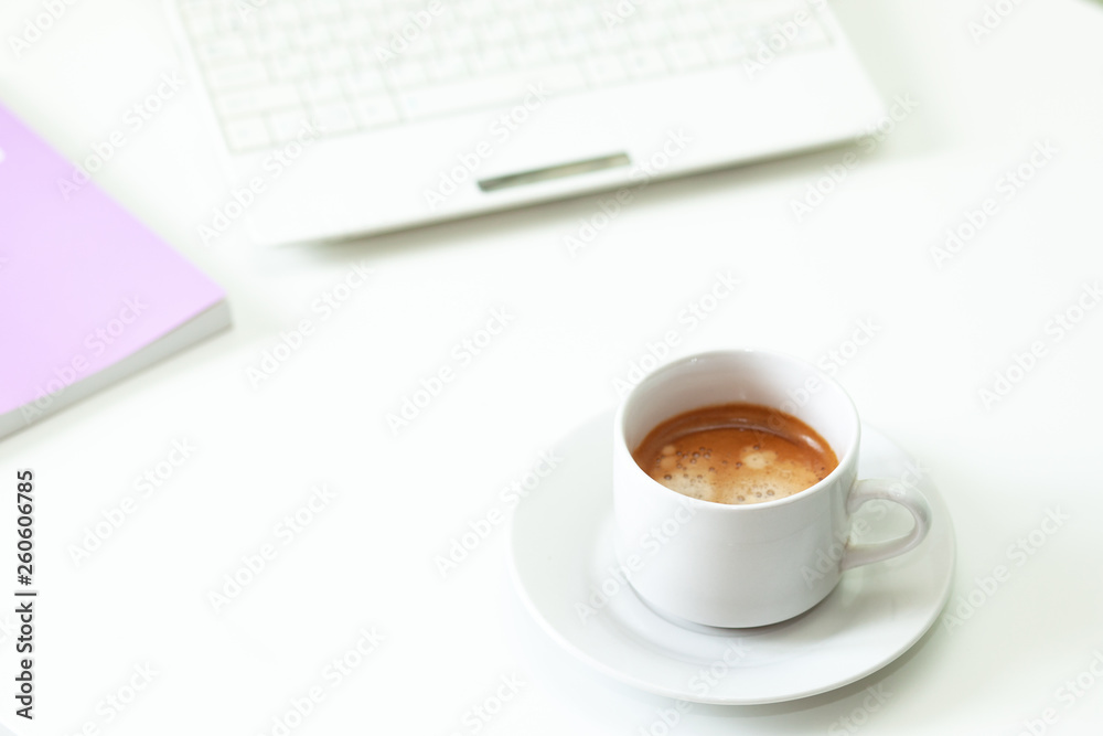 Coffee cup , laptop and lavender notpad on white table. Selective focus. Coffee cup , laptop and lavender notpad on white table. Selective focus.
