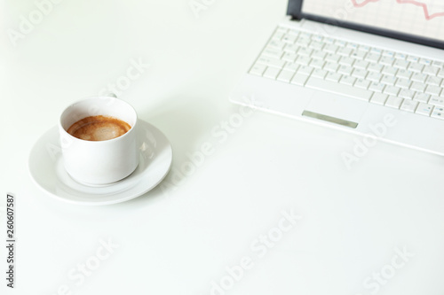 Coffee cup  laptop and on white table. Selective focus.