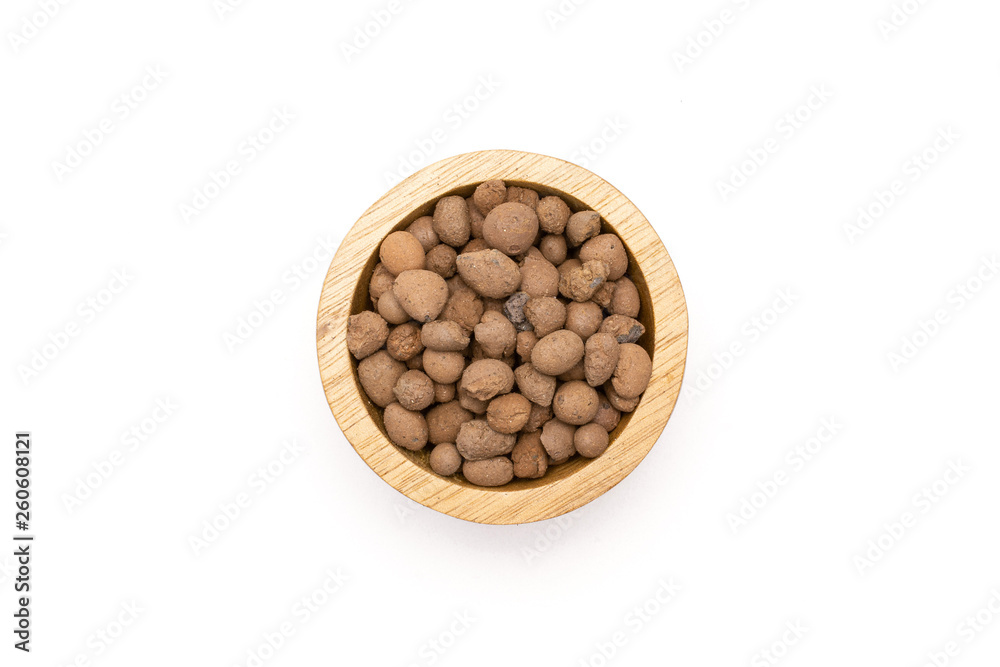 Lot of whole brown clay pebbles (leca) with wooden bowl flatlay isolated on white background Lot of whole brown clay pebbles (leca) with wooden bowl flatlay isolated on white background