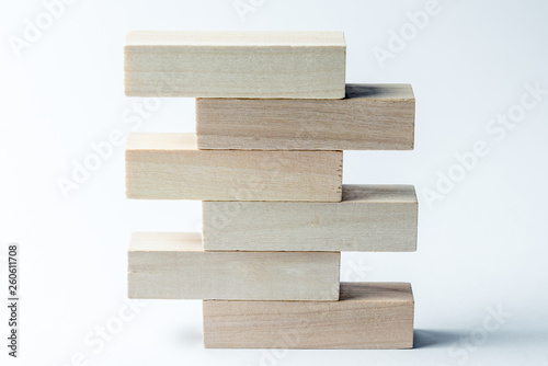 a pyramid of wooden cubes lying on top of each other with space for an inscription, on an uneven white background. Horizontal frame