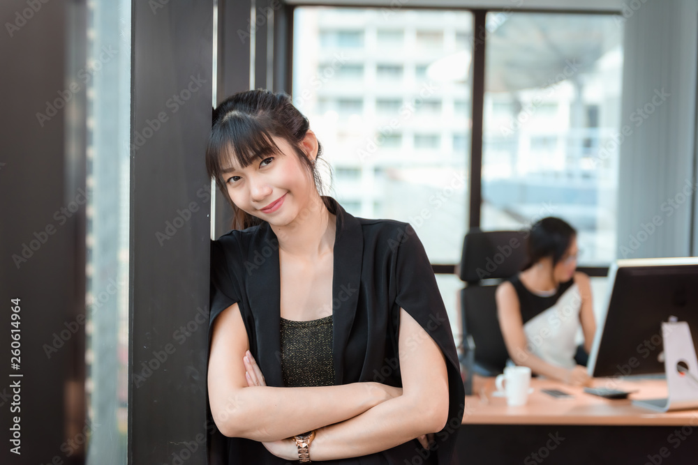 Portrait of Attractive Business Woman Standing Beside Windows Frame in Modern Office, Confident Asian Woman in Arms Crossed Posing While Looking at Camera in Office Workplace. Career and Jobs Concept Portrait of Attractive Business Woman Standing Beside Windows Frame in Modern Office, Confident Asian Woman in Arms Crossed Posing While Looking at Camera in Office Workplace. Career and Jobs Concept