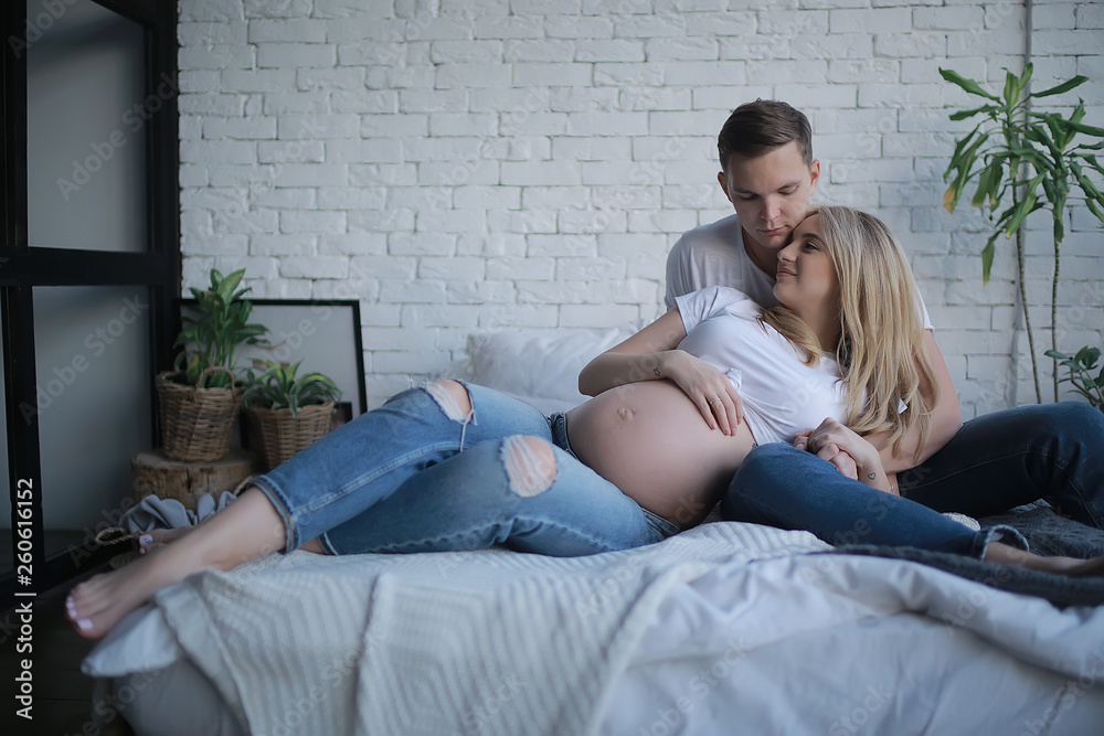 Φωτογραφία concept family pregnancy home comfort / husband and pregnant wife with a big bel