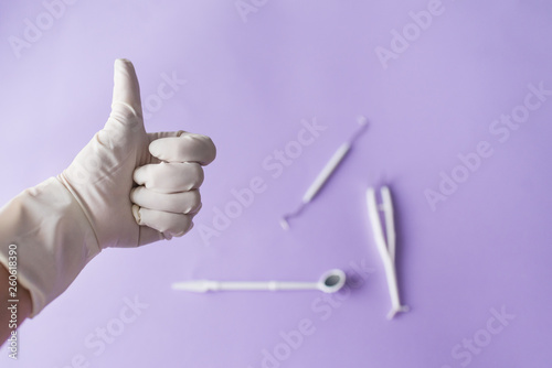 Dentist's hand and dentall instruments on colorful background photo