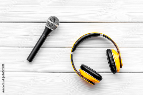 podcast record with microphone and headphones on white wooden background top view