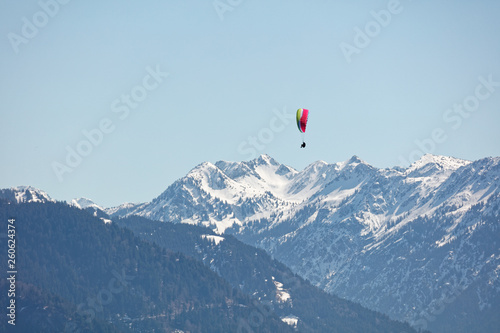 Paraglider flying over Bregenzerwald forest