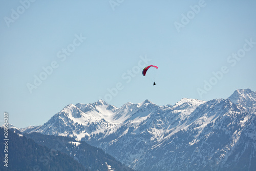 Paraglider flying over Bregenzerwald forest