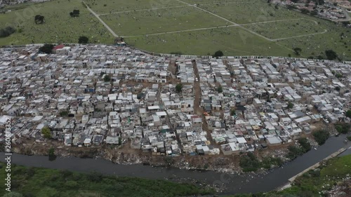 4K aerial panning view of slums or squatter camp along the Jukskei river in the Alexandra township, South Africa  photo