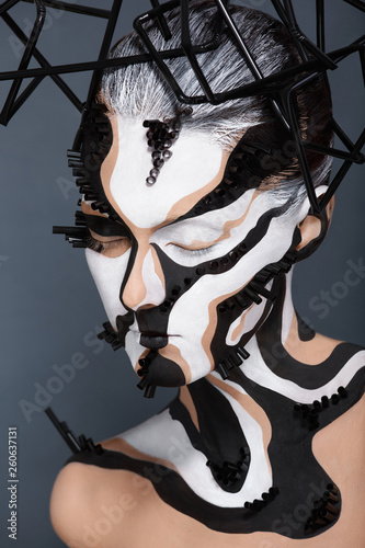 Female model with creative abstract makeup in futuristic hat
