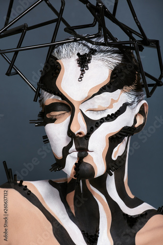 Female model with creative abstract makeup in futuristic hat