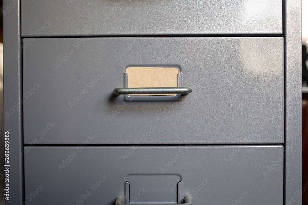 Filing cabinet with closed drawer, A brown cards for write letter, Grey silver metal colour, Administration and storage concept, closeup & Macro shot Filing cabinet with closed drawer, A brown cards for write letter, Grey silver metal colour, Administration and storage concept, closeup & Macro shot