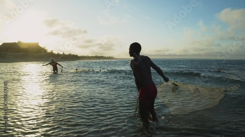 4K view of two Subsistence fisherman working a seine net in the shallow surf, Mozambique