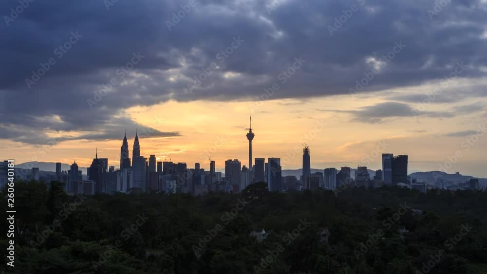 Time lapse: Silhouette of Kuala Lumpur city view during dawn overlooking the city skyline from afar with lushes green in the foreground. Federal Territory, Malaysia. Time lapse: Silhouette of Kuala Lumpur city view during dawn overlooking the city skyline from afar with lushes green in the foreground. Federal Territory, Malaysia.