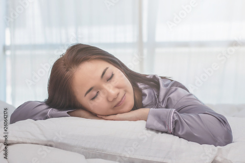 Asian woman sleep on white pillow on bed in bedroom in holiday.happy relax time.
